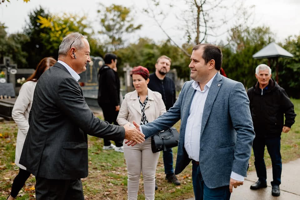 Kézfogás és beszélgetés helyiekkel egy temetőben