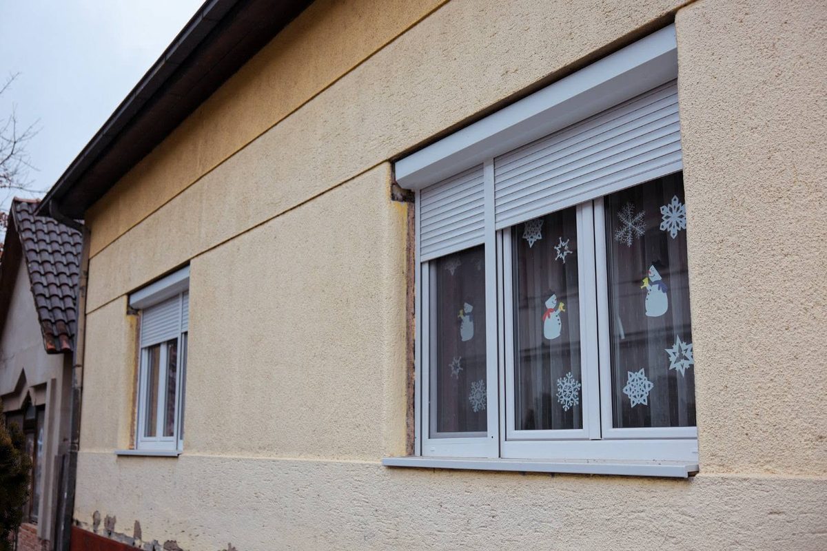 Felújított épülethomlokzat új ablakokkal és redőnyökkel