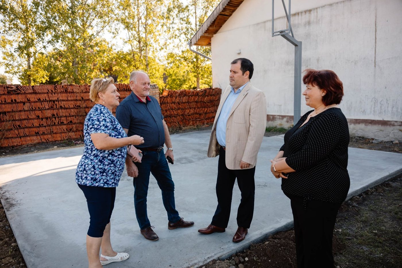 Beszélgetés helyiekkel egy új betonozott sportpályán Martonoson, 2025